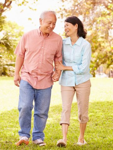 retired couple walking through park